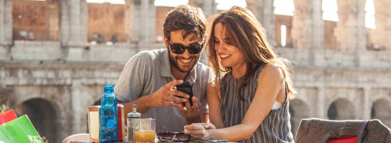 Young tourist couple looking at phone photos in Rome Tips for Italy: Young tourist couple looking at phone photos in Rome