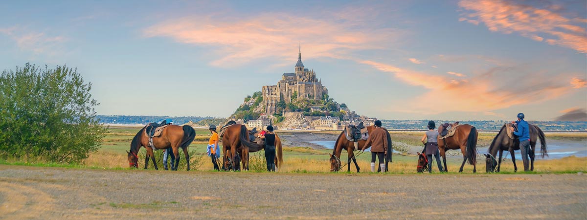 Normandy, France – Horses and toursits at Mt St Michel Normandy, France - Horses and tourists at Mt St Michel